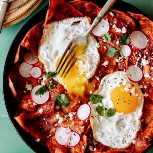 A recipe for easy Chilaquiles with a fork that has broken an egg yolk.
