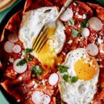 Chilaquiles in a skillet with a fork in it.