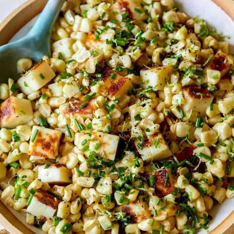 Summer corn salad recipe with a spoon.