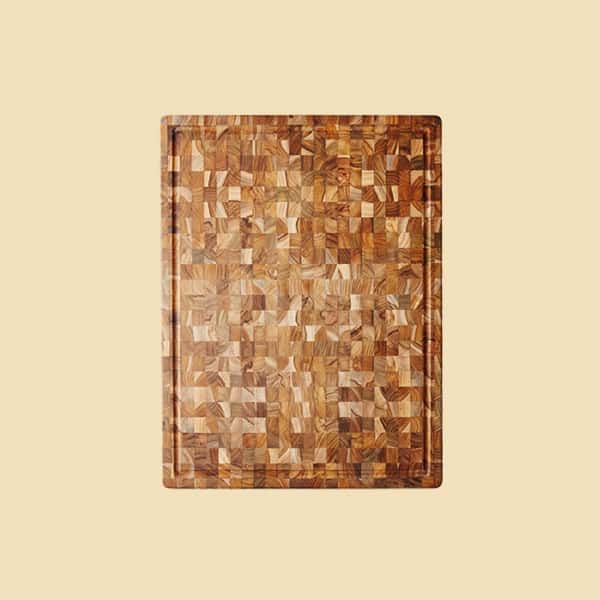 A cutting board made of teak wood with an interesting design on a yellow background.