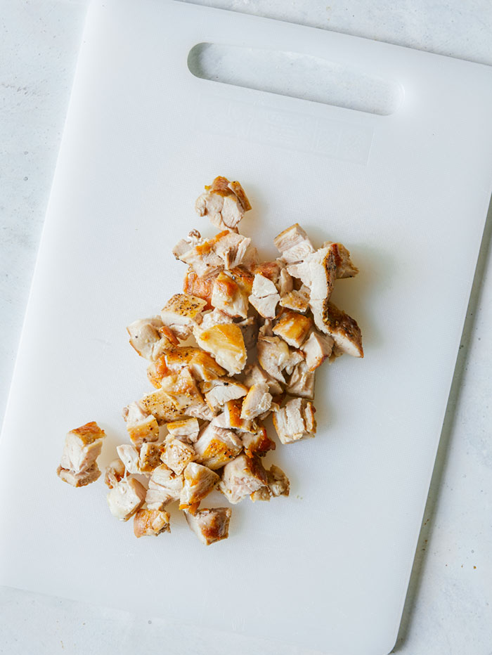 Diced chicken thighs on a cutting board.
