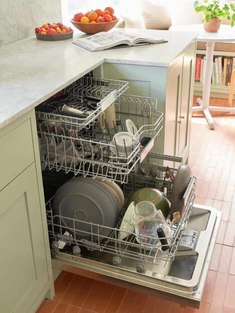 An open Bosch dishwasher full of dishes.