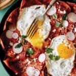 A Mexican breakfast recipe for chilaquiles with fried eggs on top.