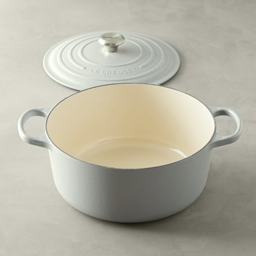 White Le Creuset Signature Round Cast Iron Dutch Oven with lid to the side.