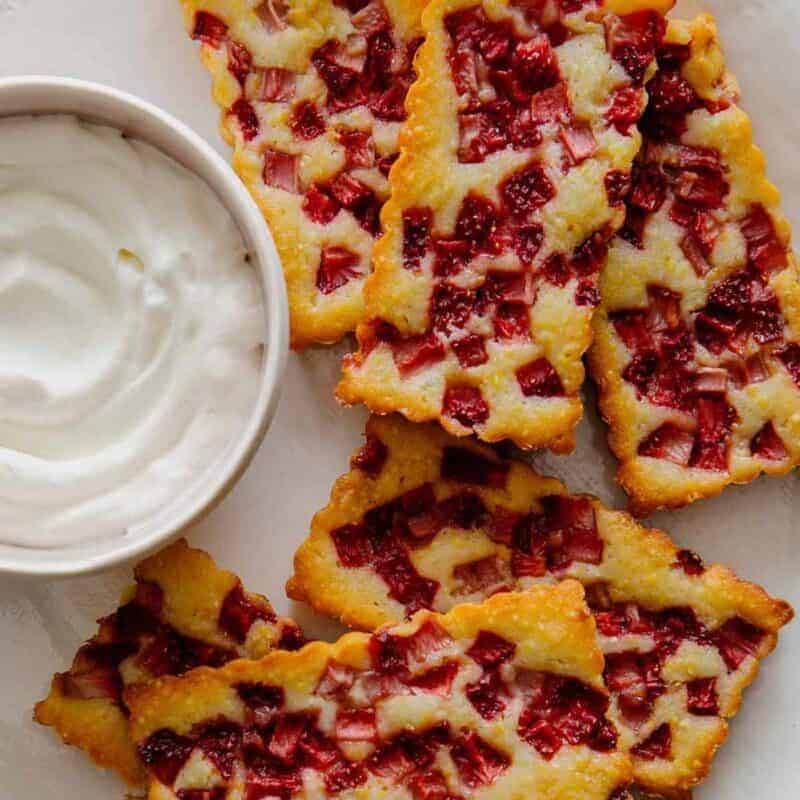 Mini Strawberry cobblers on a platter with whipped cream.