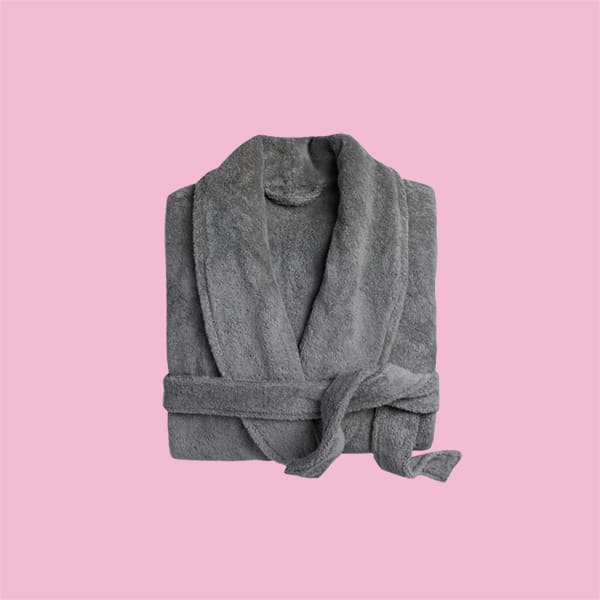 A classic plush bathrobe on a pink background.