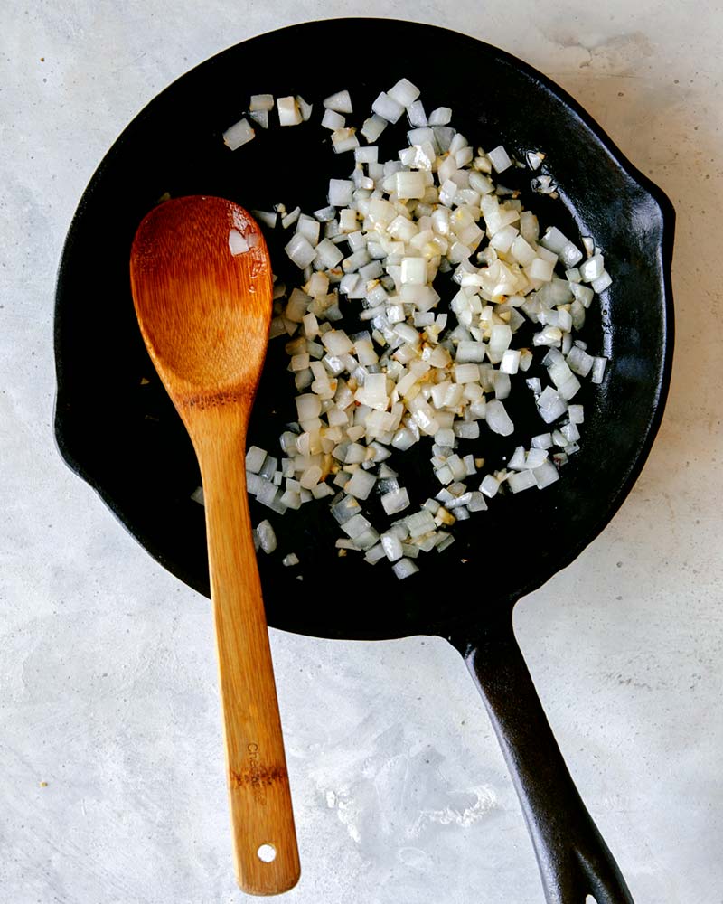 Sautéd onion and garlic in a skillet, the first step to make chilaquiles. 