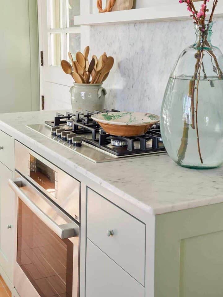 Bosch stove top oven with wooden spoons and vase on the counters.