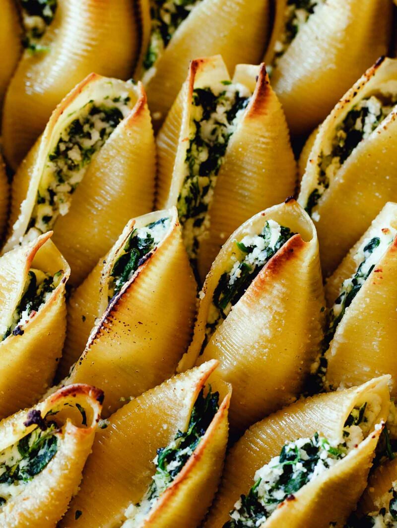 A close up image of Spinach and Ricotta Stuffed shells showing the filling in the pasta.