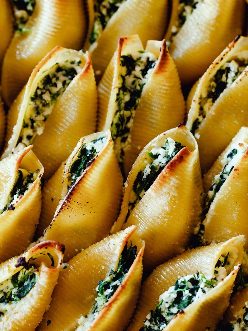 A close up image of Spinach and Ricotta Stuffed shells showing the filling in the pasta. 