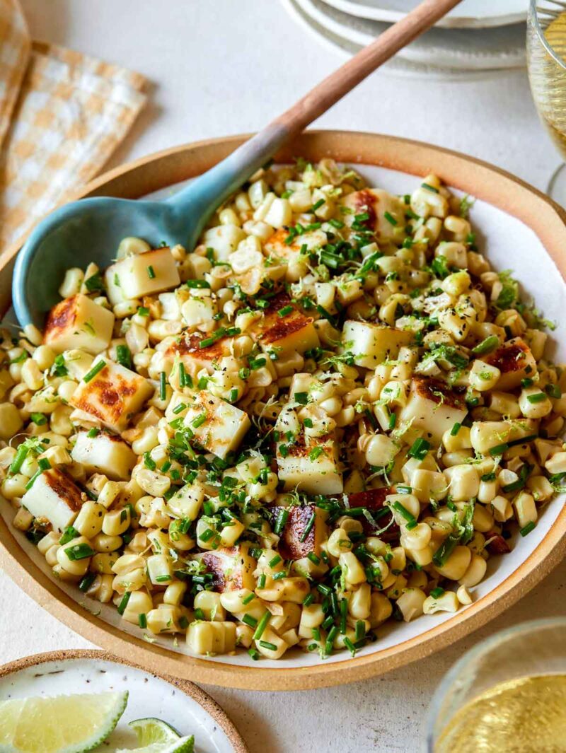 Summer corn haloumi salad in a bowl with a spoon.
