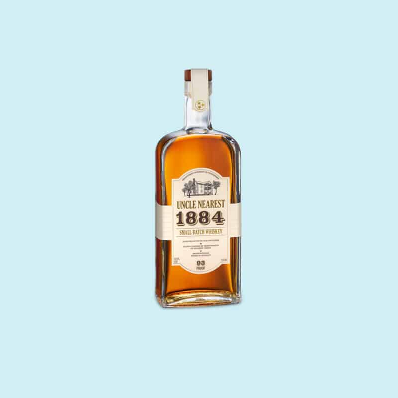 A bottle of Uncle Nearest whisky on a light blue background.