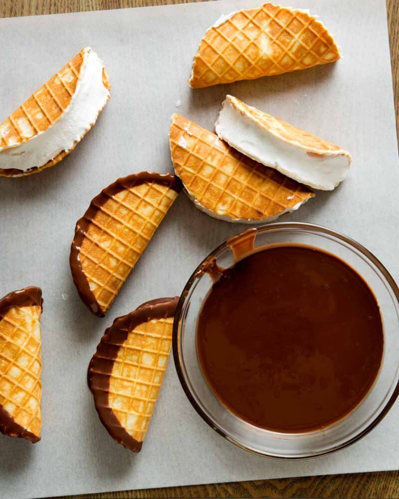 Mini Choco Tacos filled with ice cream and them dipped in a bowl of chocolate and layed out to dry.