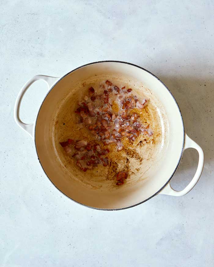 Pot with bacon rendered brown and crispy.