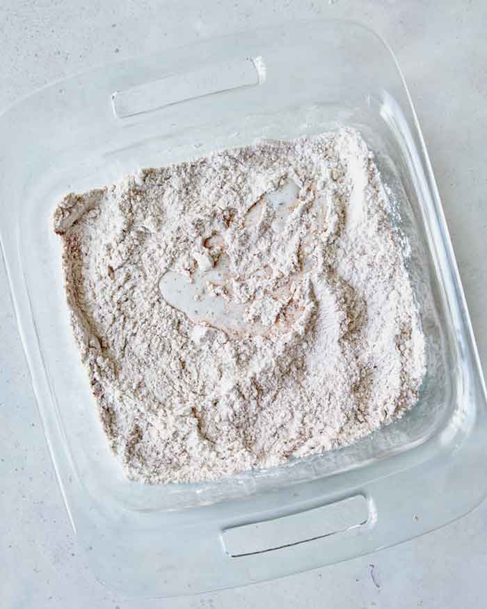 Mixed up dredging ingredients in a shallow baking dish overhead with some buttermilk.