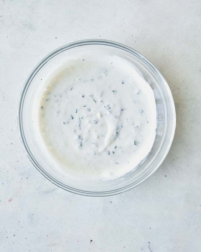 A bowl of buttermilk ranch dipping sauce ingredients all mixed together.