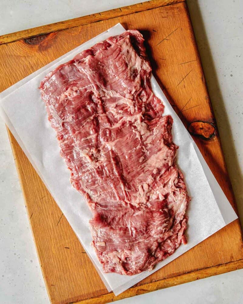 Carne Asada beef ready for marinade on a cutting board.