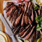 Carne Asada recipe on a cutting board with ingredients on the side.