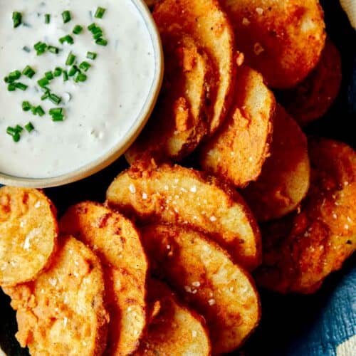 A close up of chicken fried potatoes with a ramekin of buttermilk ranch dipping sauce.