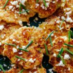 Corn Cakes close up on a platter with cheese and chives.