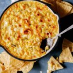 Korean Corn Cheese with a spoon in the skillet.