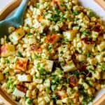 A close up of summer corn salad with a blue spoon.