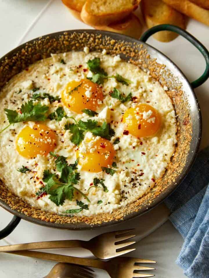 Baked sunny side eggs in a skillet.