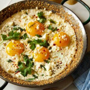 Baked sunny side eggs in a skillet.