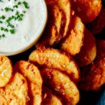 Chicken fried potatoes on a platter with ranch.