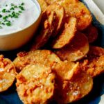 Chicken fried potatoes on a platter with ranch.