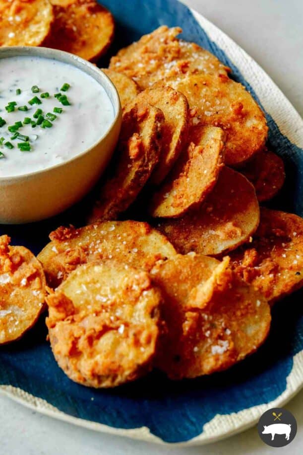 Chicken fried potatoes on a platter with ranch.