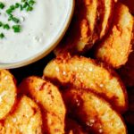 Chicken fried potatoes on a platter with ranch.