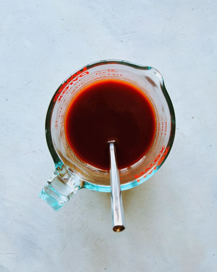 Stir together ingredients for a Michelada drink. 