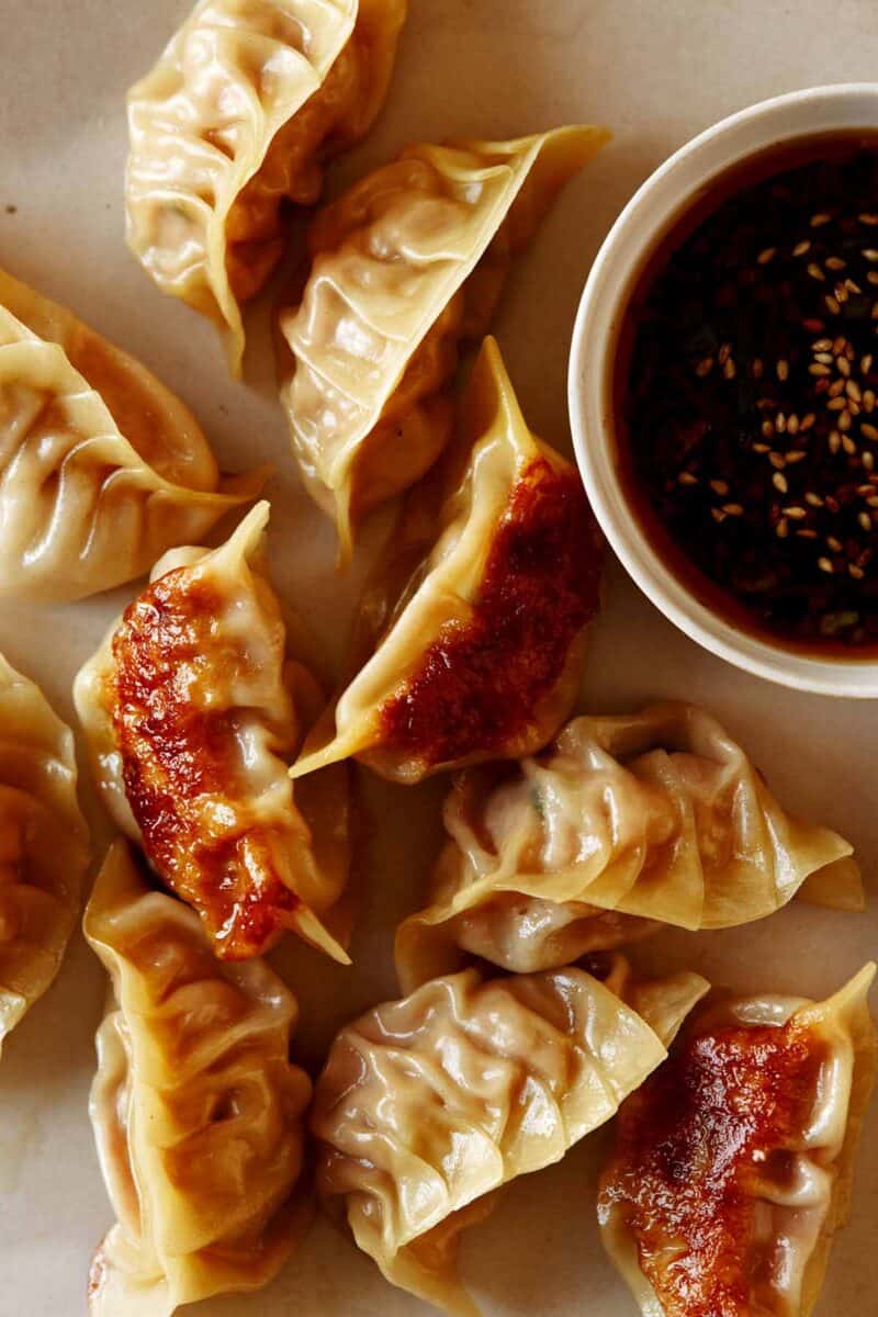 A close up on potstickers with soy sauce. 