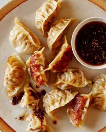 Panfried potstickers with ramekin of sauce.