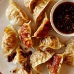 Panfried potstickers with ramekin of sauce.