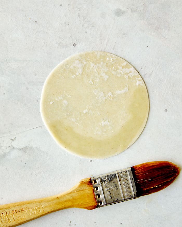 Potsticker wrapper with an egg wash brushed onto the edge.