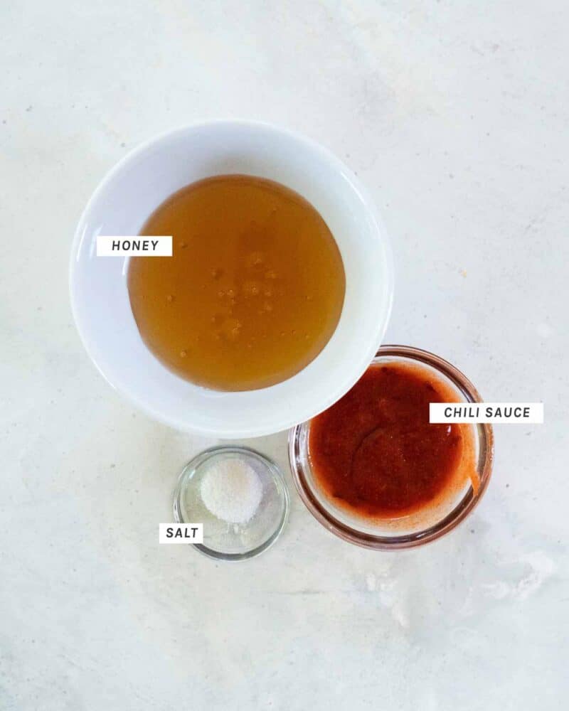 Spicy honey drizzle ingredients in bowls shot overhead.
