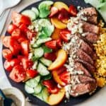 Summer steak salad on a black plate.