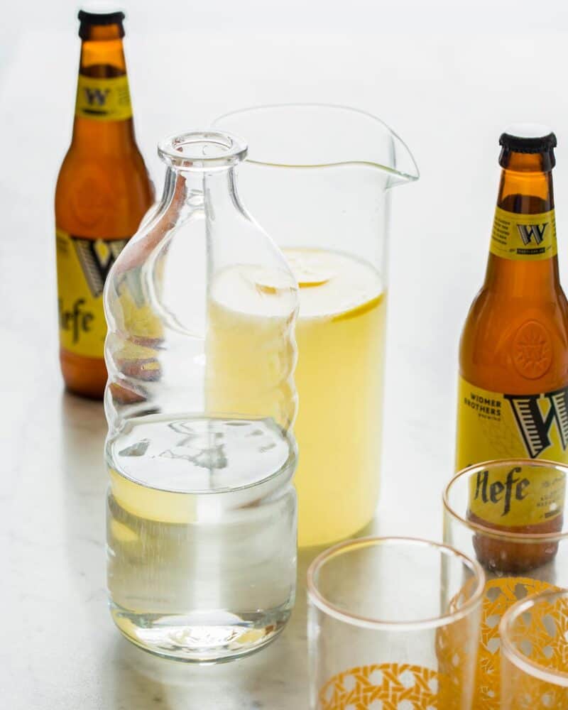 Ingredients for a summer shandy beer cocktail on a surface. 