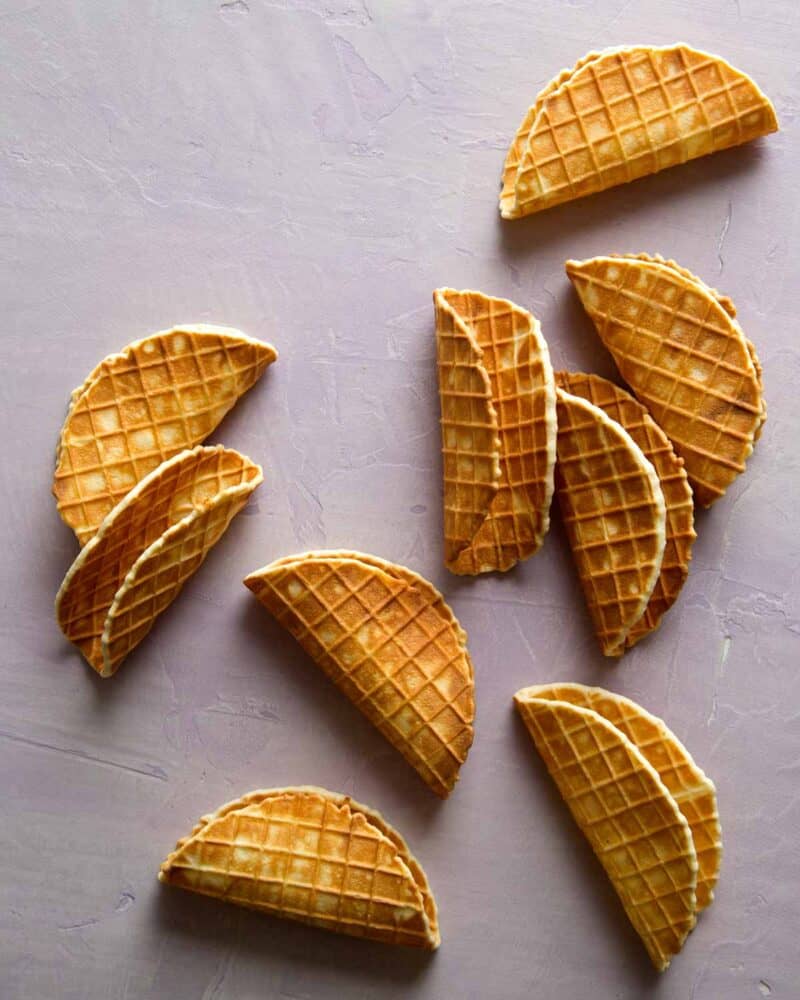 Homemade mini waffle cones shaped into tacos overhead.