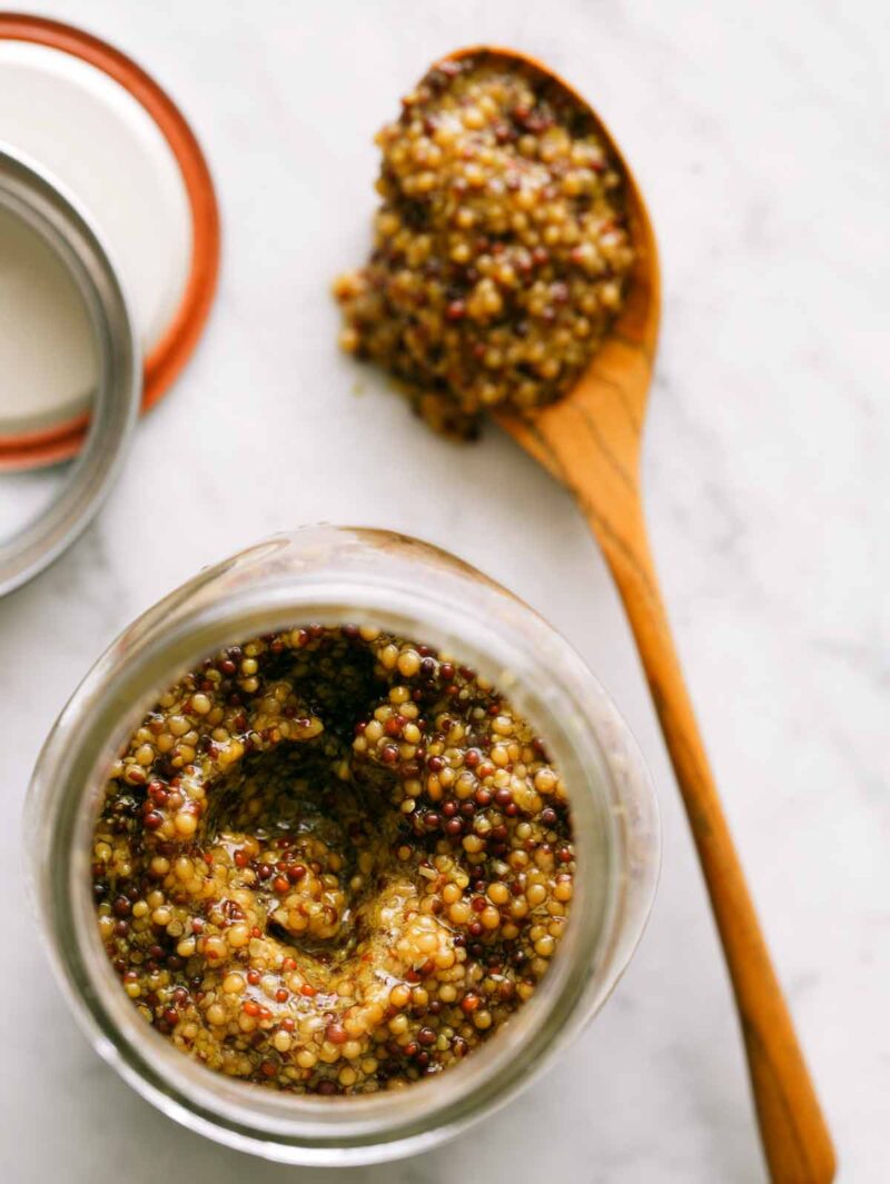 Whole Grain Mustard shows in a sterilized glass container overhead. 