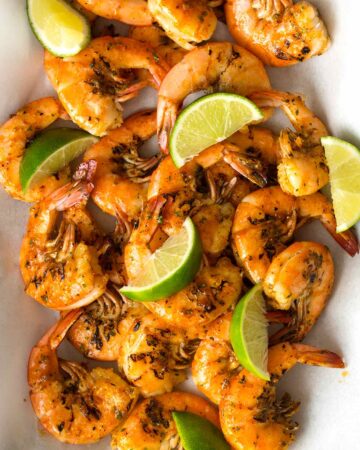 Grilled peel and easy shrimp with lime wedges.