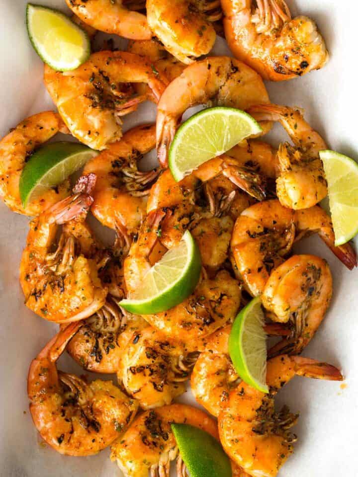 Grilled peel and easy shrimp with lime wedges.