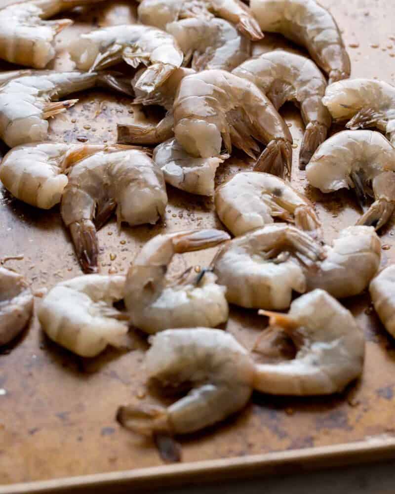 Shell on shrimp on a baking sheet.