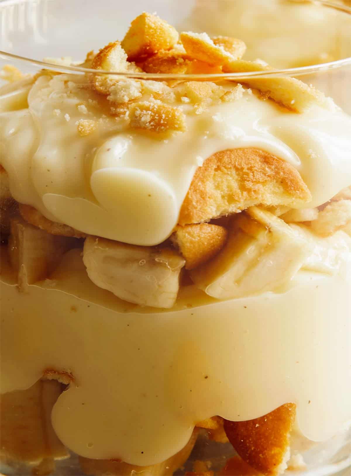 A close up on the side of a glass cup that shows the layers of banana pudding. 
