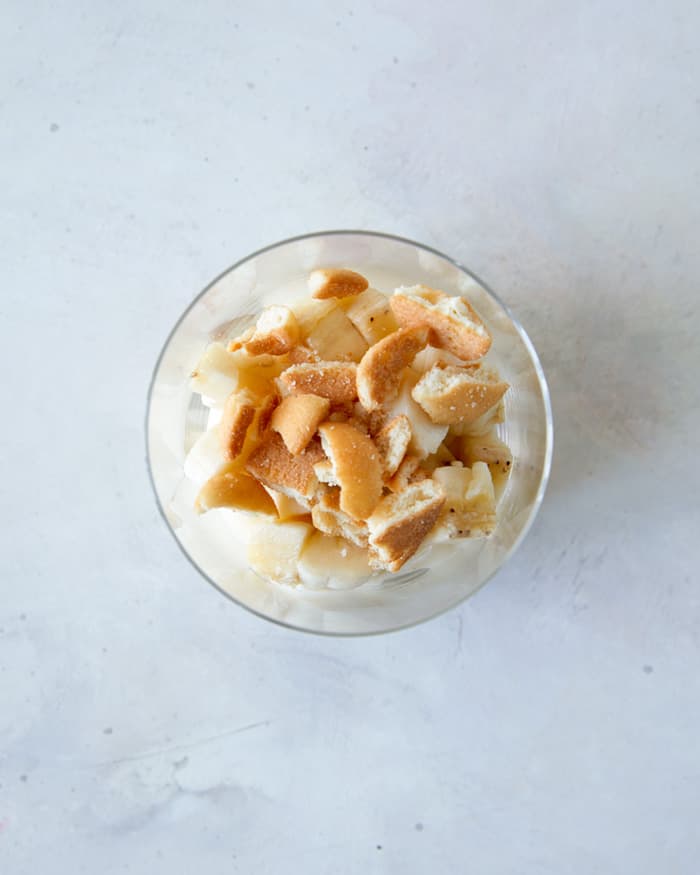 Nilla wafers and banana pudding layered in a bowl.