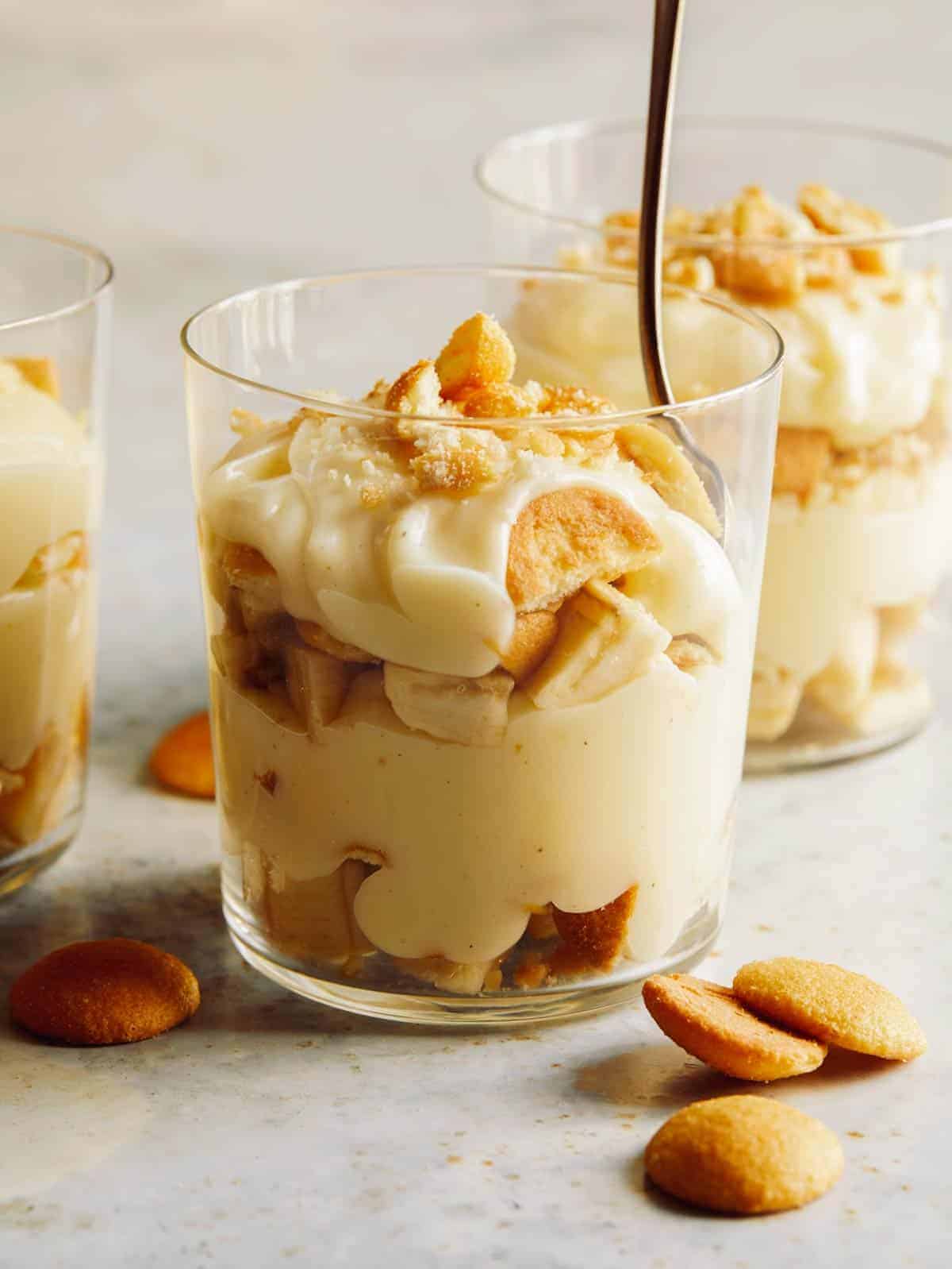 Glass cups of banana pudding with nilla waffers on the side. 