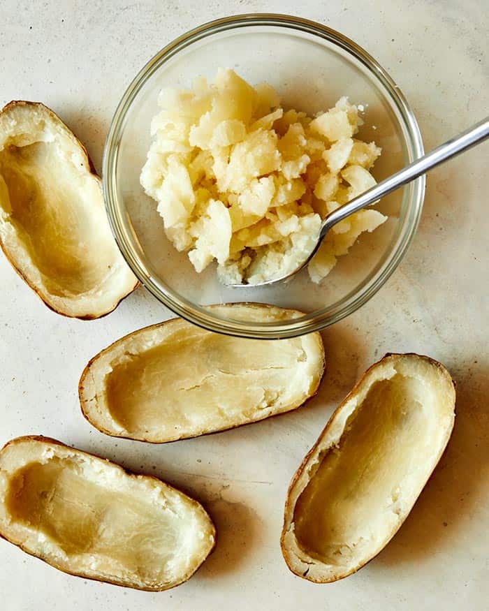 Cooked and hollowed out potato halves shot overhead.