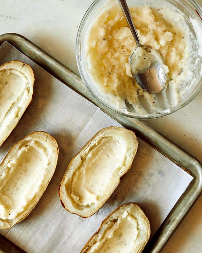 Mashed potatoes spread into the bottom of potato halves. 